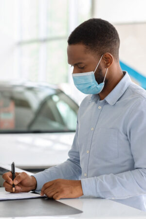 black-man-in-mask-buying-car-in-dealership-office--9B95AL6